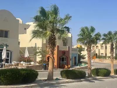 a group of palm trees in front of a building at Casa Esmeralda in Hurghada