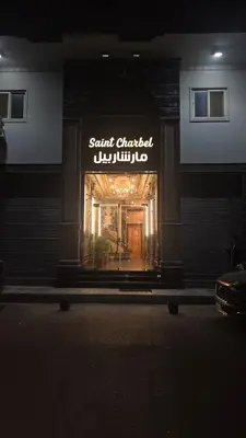 a sign for a store in a building at night at Saint charbel in Hurghada
