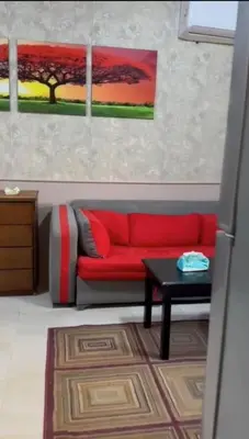 a red couch in a living room with a table at katakitu in Hurghada