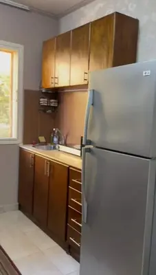 a kitchen with a stainless steel refrigerator and wooden cabinets at katakitu in Hurghada