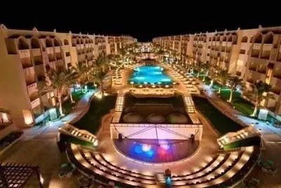 a view of a hotel with a pool at night at katakitu in Hurghada