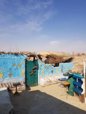 a room with a blue wall with a table and chairs at Seheil Antique House in Jazīrat Salūjah