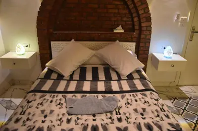 a bedroom with a large bed with two night stands at Isis Magic House in Luxor