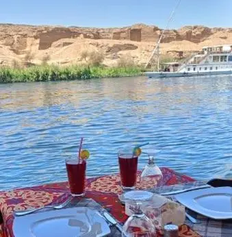 a table with two glasses on top of the water at Nile SE Felucca nile cruise private tour in Naj‘ al ‘Amrāb