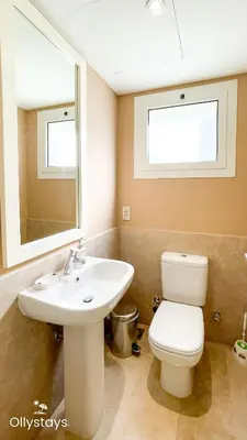 a bathroom with a sink and a toilet and a mirror at Ollystays Joubal Lagoon 3BR Villa Heated Pool in Hurghada