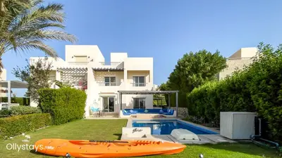 a villa with a swimming pool and a house at Ollystays Joubal Lagoon 3BR Villa Heated Pool in Hurghada
