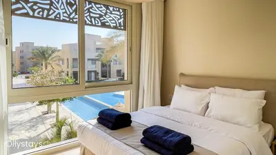 a bedroom with a bed and a large window at Ollystays Mangroovy 2 BR Beach and Pool Free access in Hurghada