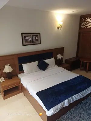 a bedroom with a large bed with a blue blanket at Palma Resort Apartments and Suites with Private Beach in Hurghada