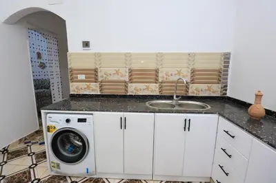 a kitchen with a washing machine and a sink at Akhet House in Luxor