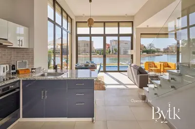 a kitchen with blue cabinets and a view of a living room at BYTK - Casa De Familia in Hurghada