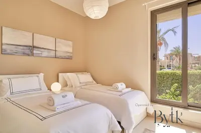 two beds in a room with a window at BYTK - Casa De Familia in Hurghada