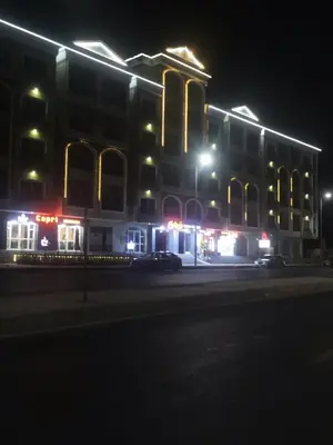 a large building with lights on a street at night at Juliana beach resort in Hurghada
