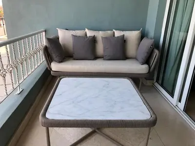 a couch on a balcony with a coffee table at New Marina Deluxe in Hurghada