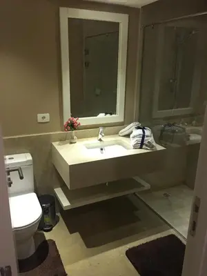 a bathroom with a sink and a toilet and a mirror at Sabina Comfort Residence in Hurghada