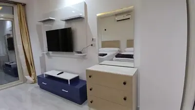 a bedroom with a dresser and a mirror and a bed at Mirage bay aquapark and resort 110 C minaland in Hurghada