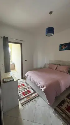 a bedroom with a pink bed and a rug at Ferienwohnung Sahl Hasheesh in Hurghada