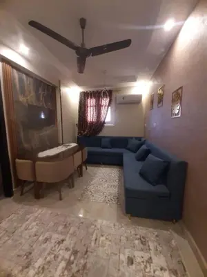 a living room with a blue couch and a table at Horus Heights in Idfu