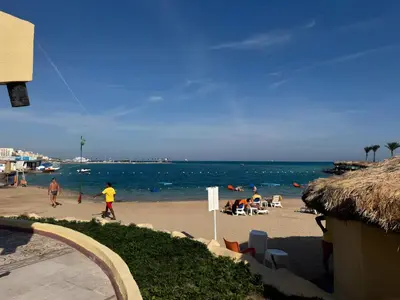 a beach with people on the sand and the water at 4 Bedroom Seaside Hurghada Escape in Hurghada