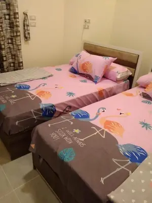 two twin beds in a bedroom with avertisement for at Casablanca Beach Appartment in Hurghada