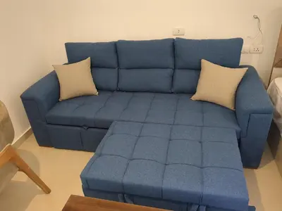 a blue couch with two pillows in a living room at Magawish Studio 2 with Pool in Hurghada