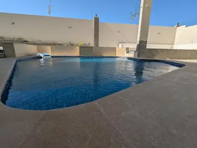 a swimming pool with blue water in front of a building at Magawish Studio 2 with Pool in Hurghada