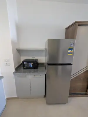 a kitchen with a refrigerator and a microwave on a counter at Magawish Studio 2 with Pool in Hurghada