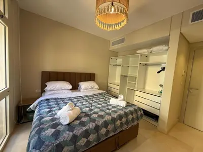 a bedroom with a bed with towels on it at Cozy 1BR GF Mangroovy Residence in Hurghada