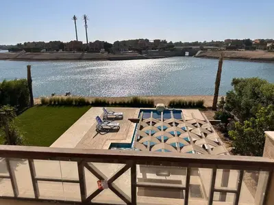 a balcony with a view of a body of water at Exclusive Villa in Sabina • 4 BR • Private Pool in Hurghada