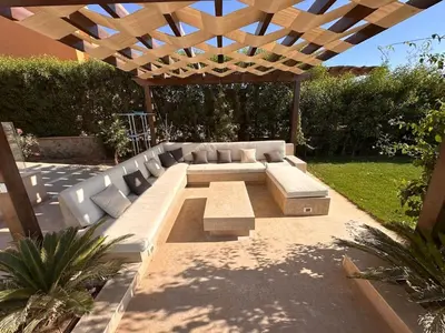 a patio with a couch under a wooden pergola at Exclusive Villa in Sabina • 4 BR • Private Pool in Hurghada