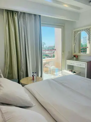 a bedroom with a large white bed and a balcony at touristic center in Hurghada
