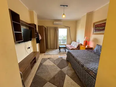 a hotel room with a bed and a television at Studio in Hurghada