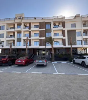 a large building with cars parked in a parking lot at 422batthepavillionImperialHurghada in Hurghada