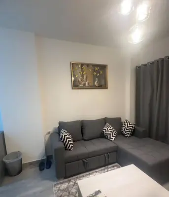 a living room with a gray couch and a painting at 422batthepavillionImperialHurghada in Hurghada