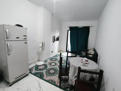 a small kitchen with a table and a refrigerator at Turtles Beach Chalet in Hurghada