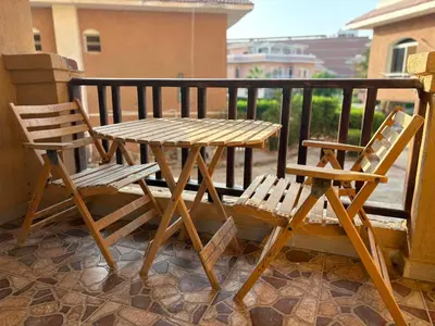 a wooden table and two chairs on a balcony at Modern 1BR Seaside Apartment C1 in Turtles Beach in Hurghada