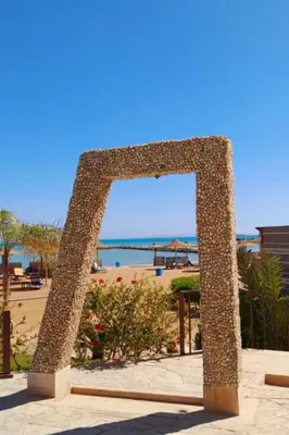a stone arch with a view of the beach at Modern 1BR Seaside Apartment C1 in Turtles Beach in Hurghada