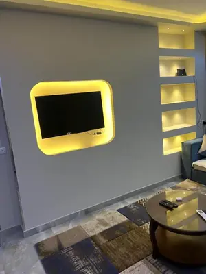 a living room with a tv on a wall at القيادات صف ثاني in Hurghada