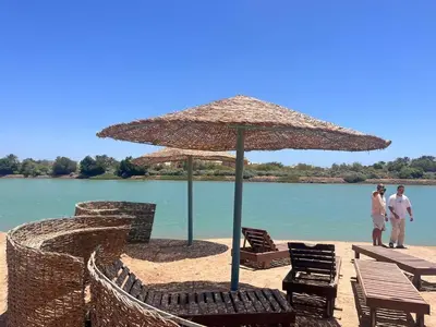 two people standing on a beach under an umbrella at West Golf beautiful Townhouse in Hurghada