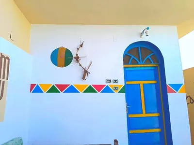 a room with a blue door and a clock on the wall at Shellaly Ca Nubian Guest2 House in Jazīrat Salūjah