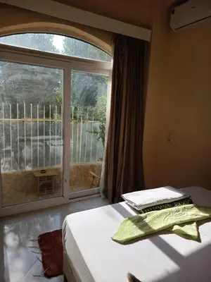 a bedroom with a bed and a large window at 2 Karima house B in Al Aqālitah