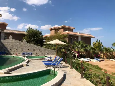 a resort with a pool and chairs and a building at Turtles beach resort in Hurghada