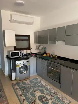 a kitchen with a washing machine and a microwave at Turtles beach resort in Hurghada