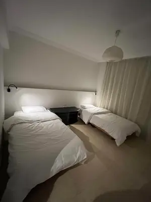 two beds in a hotel room with white sheets at Sea front 2 bedrooms apartment in Esplanada in Hurghada