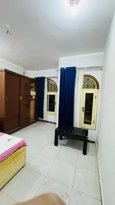 a room with blue curtains and a bench in it at Many hahaha in Luxor