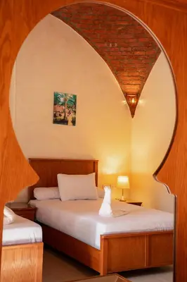 two beds in a room with an archway at opal legacy luxor in Luxor