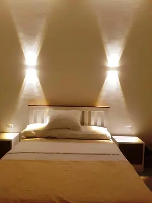 a bedroom with a bed with two lights on it at Malika House in Luxor