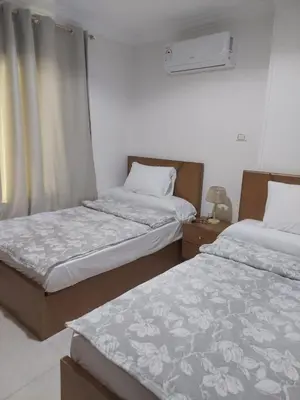 a bedroom with two beds and a window at Hurghada Apartment with pool in Hurghada