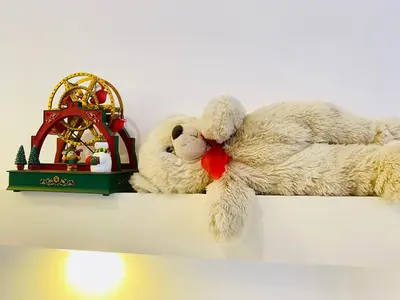 a stuffed teddy bear laying on top of a shelf at Alena guest house in Jazīrat al ‘Awwāmīyah