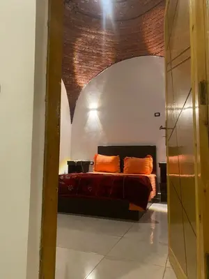 a bedroom with a bed with orange pillows at الاقصر مركز القرنة مدينة القرنة الجديدة بجوار كافتيريا الميدان in ‘Ezbet Abu Ḥabashi