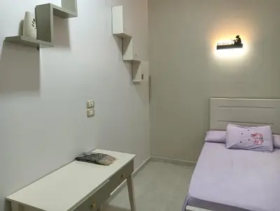 a small room with a bed and a table at noreno guest house in Aswan